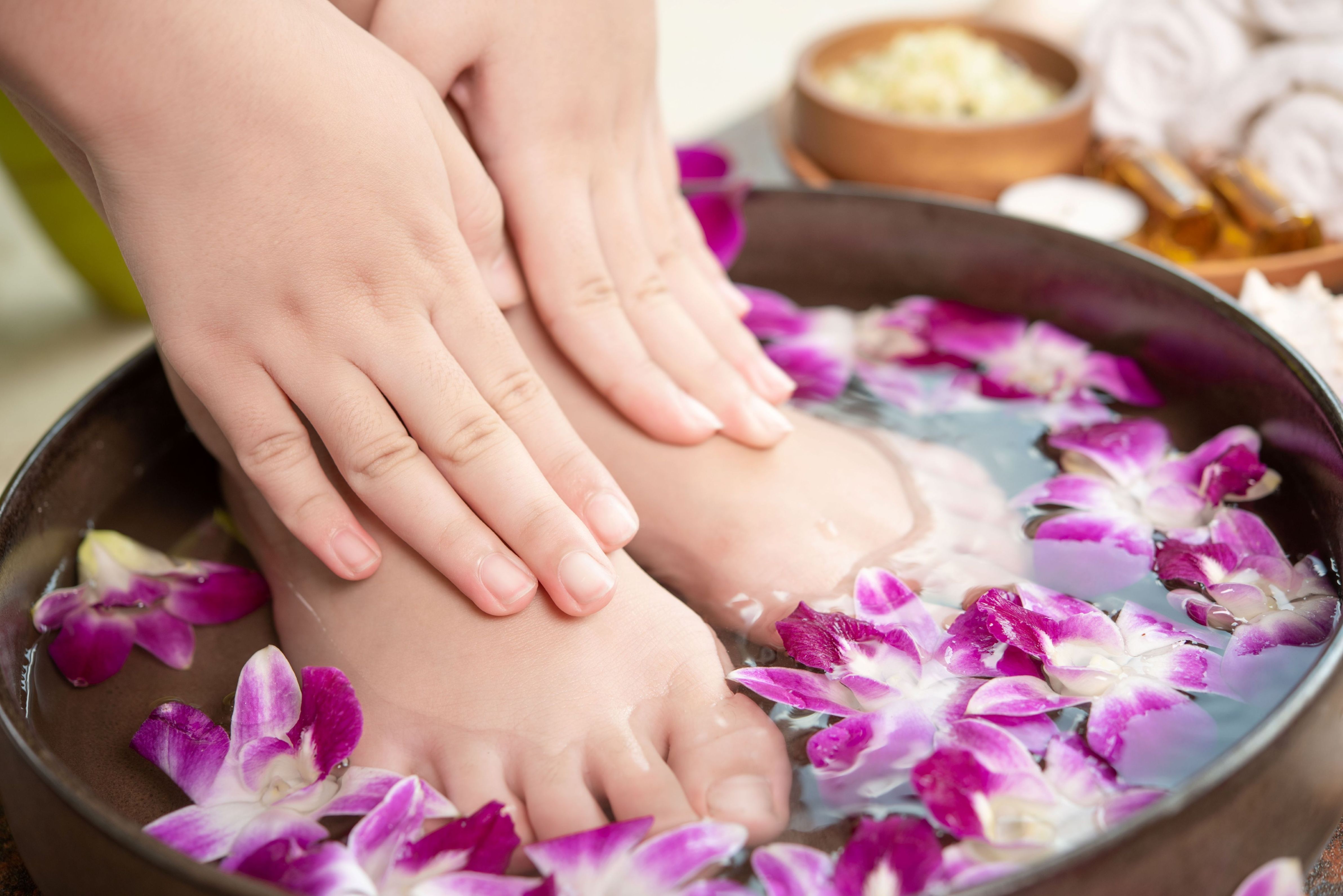 spa treatment product female feet hand spa orchid flowers ceramic bowl